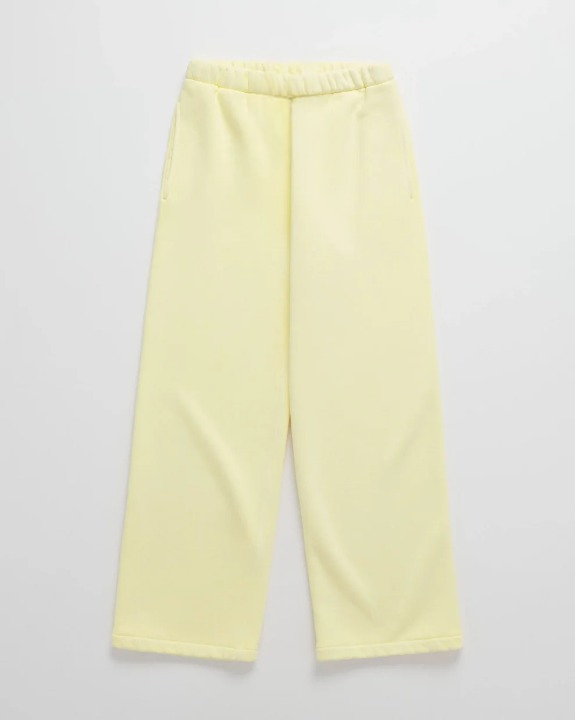 Hellgelbe Jogginghose mit elastischem Bund und seitlichen Eingriffstaschen, flach ausgelegt von vorn. 6