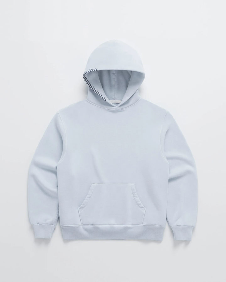 Hellblauer Kapuzenpullover von vorn mit Bauchtasche und dunkelblauer Zierstichen entlang der Kapuze. 4