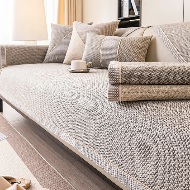 Zwei gefaltete Sofabezüge in Grau und Beige liegen auf dem beigegrauen Bezug auf dem Sofa. 6