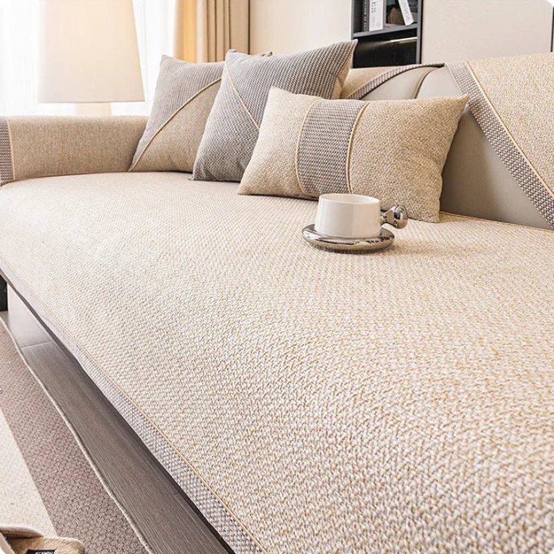 Sofabezug in hellem Beige auf dem Sofa, kombiniert mit beigen und grauen Kissen und einer Tasse. 9