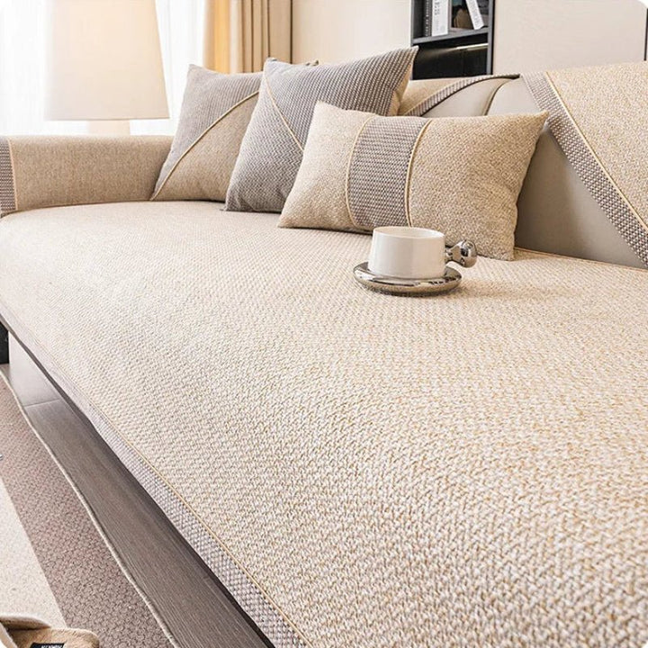 Sofabezug in hellem Beige auf dem Sofa, kombiniert mit beigen und grauen Kissen und einer Tasse. 9
