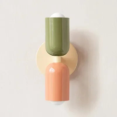 Wandlampe mit olivgrünem oberem Schirm, cremefarbener Wandplatte und lachsfarbenem unterem Schirm vor heller Wand. 19