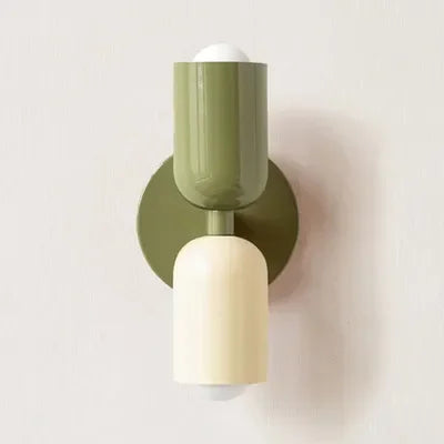 Wandlampe mit olivgrünem oberem Schirm, olivgrüner Wandplatte und cremefarbenem unterem Schirm vor heller Wand. 15