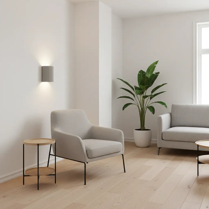 Helle Wandlampe in Grau neben einem Sessel in minimalistischem Wohnzimmer mit Parkett und Pflanze 5