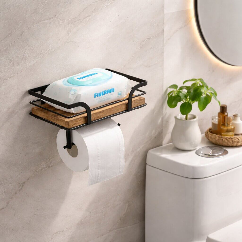 Halter an heller Wand neben Toilettenspülkasten, auf der Ablage liegt eine Packung Feuchttücher, darunter hängt eine Toilettenpapierrolle. 2