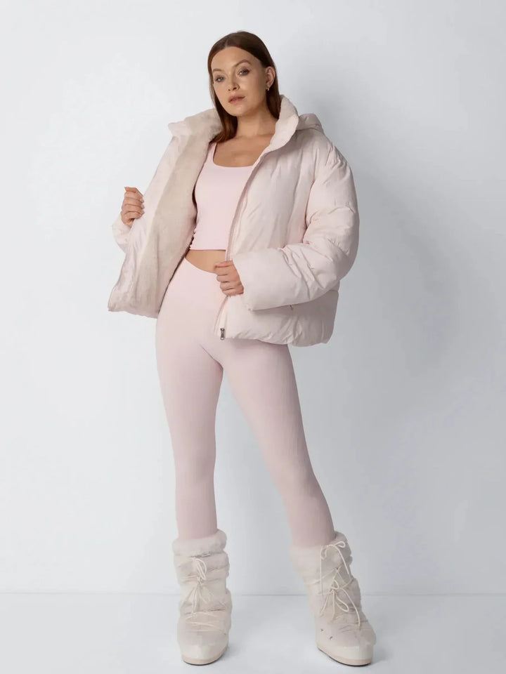 Model in rosafarbener Steppjacke hält die Jacke offen und zeigt das cremefarbene Fleecefutter 8
