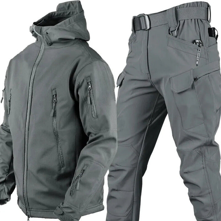 Graues Set aus Kapuzenjacke und Cargohose mit Gürtel und Beintaschen, freigestellt vor weißem Hintergrund. 10