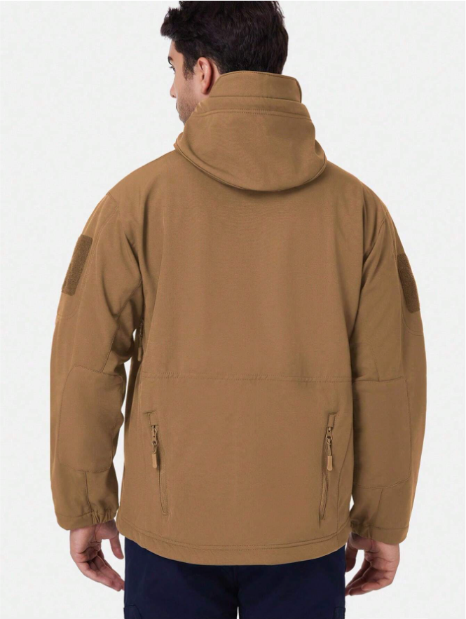 Rückansicht der sandbraunen Jacke am Model mit Kapuze, Klettflächen an den Oberarmen und zwei Reißverschlusstaschen am Rücken. 14