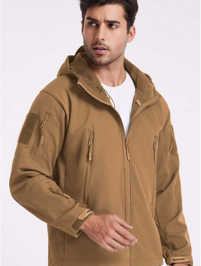 Mann in sandbrauner Jacke über weißem T-Shirt, Kapuze mit Fleecefutter im Kragen und Zugbändern sichtbar. 17